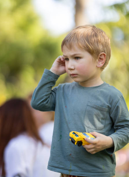 istock A young boy is holding a toy car and talking on a cell phone 2160321165