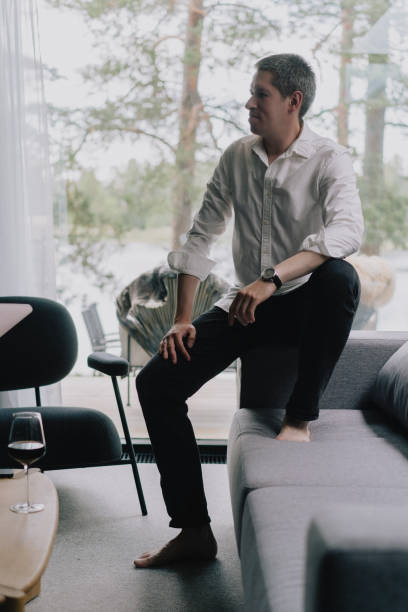 istock A man sitting on a couch holding mobile phone or smartphone in hand. 2160324515