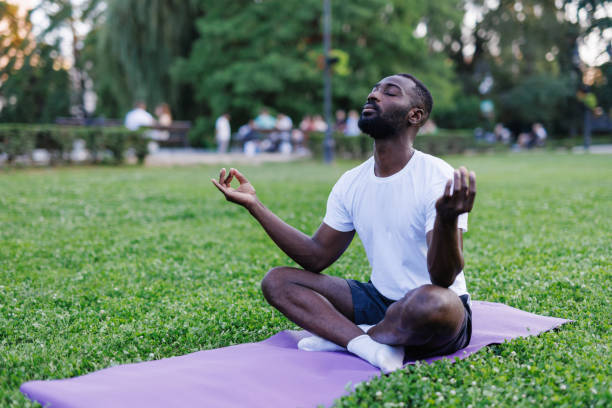 istock Man meditating in nature, seated cross-legged on mat 2160325580