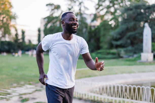 istock Man jogging in park with greenery, trees in background 2160325706