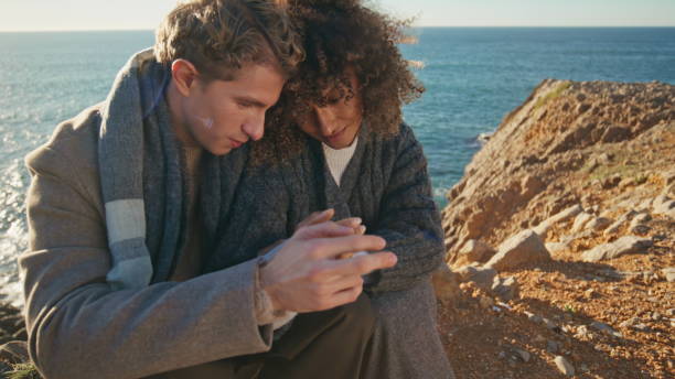 istock Peaceful couple sitting cliff touching hands at evening closeup. Tender pair 2160328870