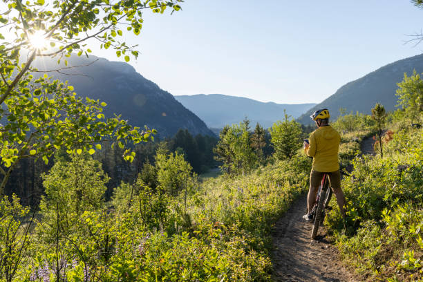 istock Mountain biker pauses in meadow at sunrise 2160330645