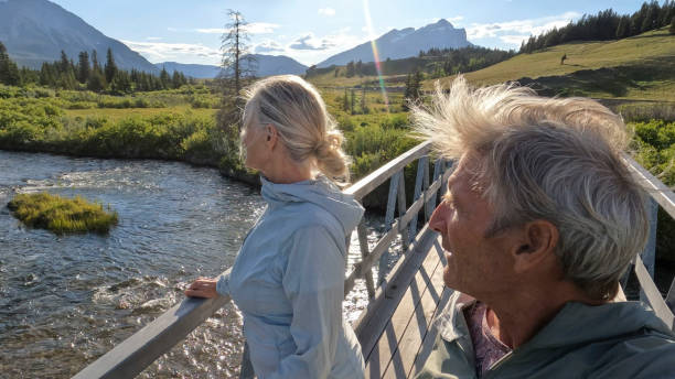 istock Senior couple walk across bridge over river 2160331214