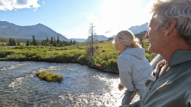 istock Senior couple walk across bridge over river 2160331217