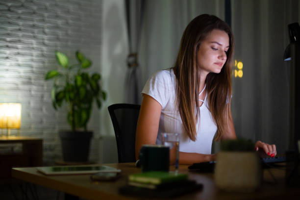 istock Young woman working late at night in her home office 2160332703