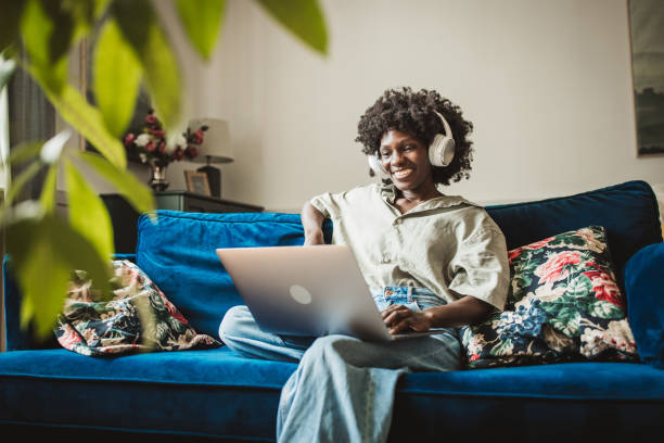 istock Young woman using a laptop at home 2160332824