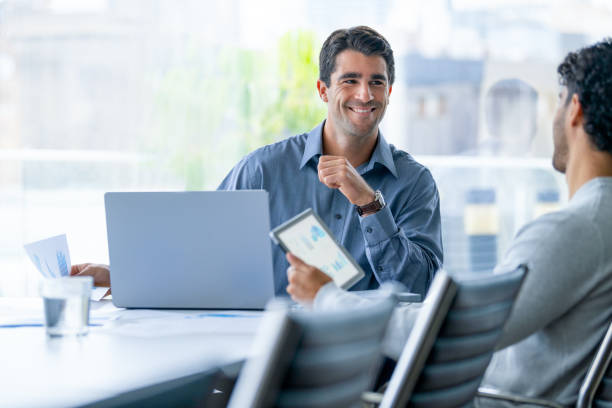 istock Two businessmen working on a digital tablet and laptop computer in the office. 2160337377