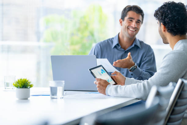 istock Two businessmen working on a digital tablet and laptop computer in the office. 2160337509