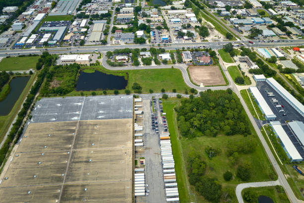 istock Big corporate shipment center with many cargo semi trucks unloading and uploading retail products for further retail shipment. Global market concept 2160338418