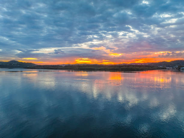 istock Sunrise over the bay water with clouds and reflections 2160354198