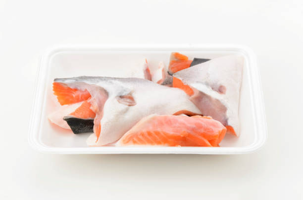 istock Silver salmon scraps in foam food tray on white background. 2160354868