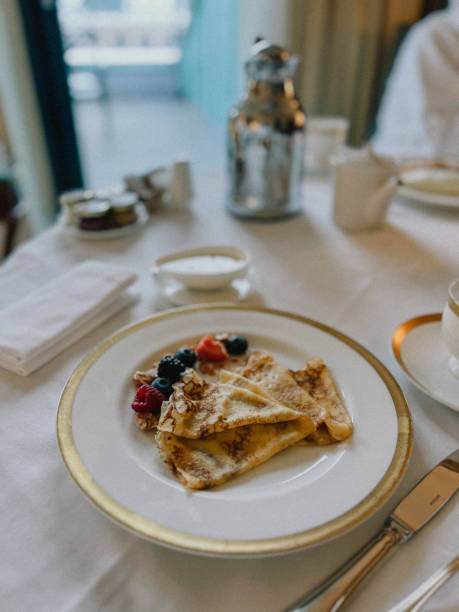 istock Delicious hotel breakfast with crepes, berries, cityscape backdrop 2160355438