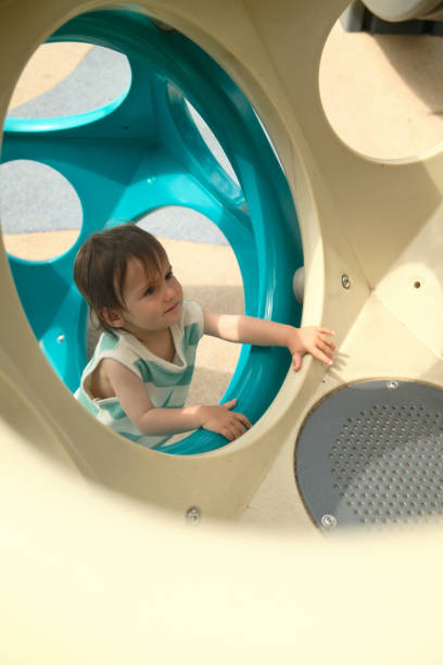 istock Toddler exploring playground equipment at park 2160359786