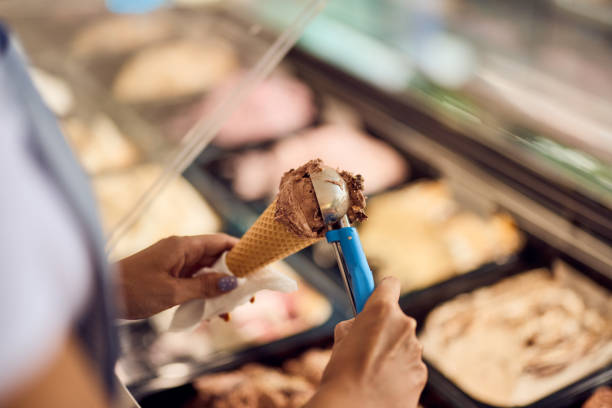 istock Female worker putting a scoop of ice cream on a cone. 2160359825
