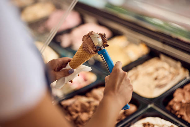Close-up of a chocolate ice cream in a cone, putting with a scooper. stock photo