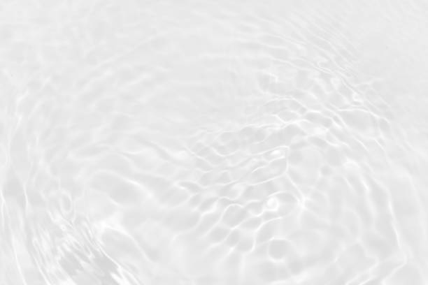 istock White water with ripples on the surface. Defocus blurred transparent white colored clear calm water surface texture with splashes and bubbles. Water waves with shining pattern texture background. 2160360196