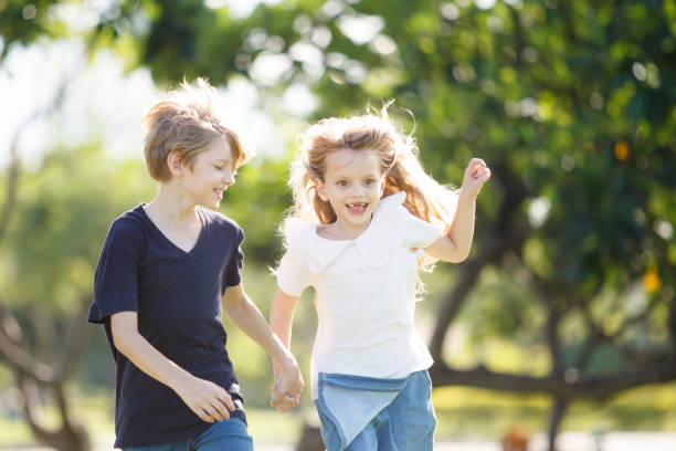 istock White children running together at the park. 2160362792