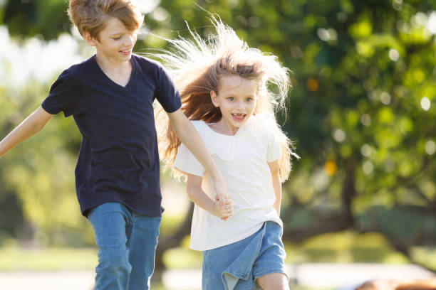 istock White children running together at the park. 2160362797