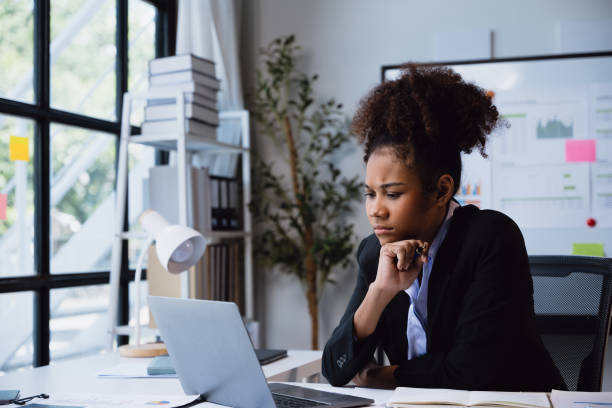 istock African Businesswomanman is seriously stressed and upset working on tablet and document paperwork and headache due to office syndrome on laptop and paperwork in the office. 2160367971