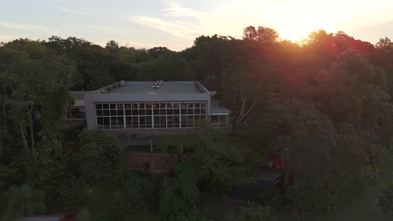 Aerial view of a party room surrounded by a green environment, with an amazing sunset over the Paraná River in the background, Misiones, Posadas.