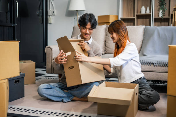 istock Indoors, a young couple happily packs cardboard boxes, preparing for a move. They share smiles and excitement, embracing new beginnings together in their new home, filled with love and anticipation 2160377435