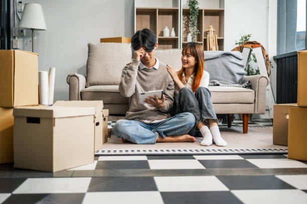 istock A stressed young couple faces financial challenges, struggling with debt and bills. Despite the hardships, they turn to each other for support, holding hands and confronting their issues together. 2160377492