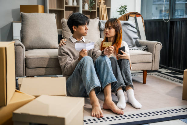 istock A stressed young couple faces financial challenges, struggling with debt and bills. Despite the hardships, they turn to each other for support, holding hands and confronting their issues together. 2160377498