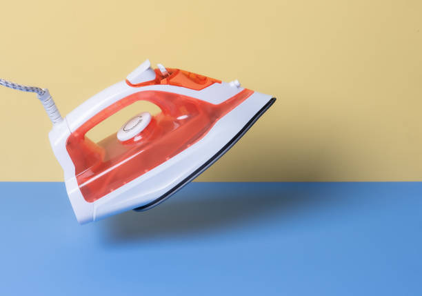 Steam iron on yellow and blue background