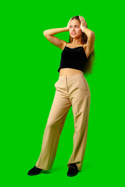 istock Young Woman Making a Surprised Face in Front of Green Screen 2160383203