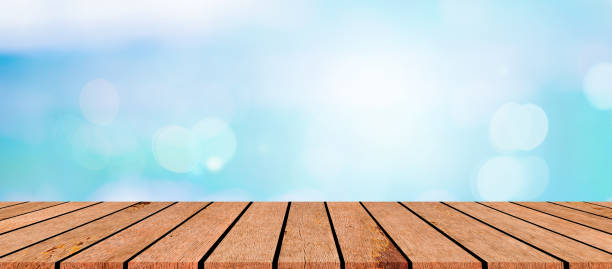 istock blurred natural blue sea gradient glow backdrop wall with vintage brown wood texture panel color background table top for advertise,show,promote products on display 2160387190