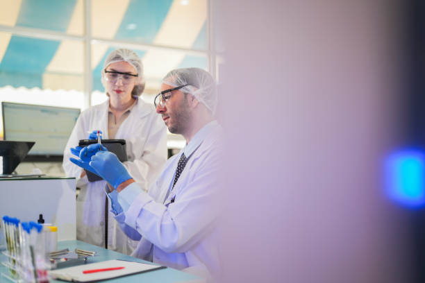 istock scientists perform experiments and record data. people arranges equipment with test tubes and chemicals for producing medicine and biochemistry. man hold tubes of chemical liquids and plant samples. 2160388578