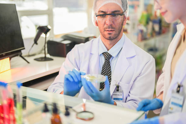 istock scientists perform experiments and record data. people arranges equipment with test tubes and chemicals for producing medicine and biochemistry. man hold tubes of chemical liquids and plant samples. 2160389005