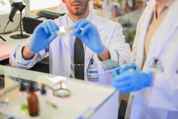 istock scientists perform experiments and record data. people arranges equipment with test tubes and chemicals for producing medicine and biochemistry. man hold tubes of chemical liquids and plant samples. 2160389022