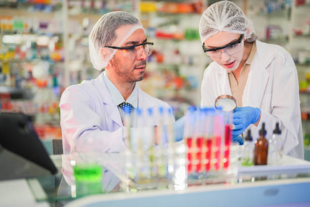 istock scientists perform experiments and record data. people arranges equipment with test tubes and chemicals for producing medicine and biochemistry. man hold tubes of chemical liquids and plant samples. 2160389095