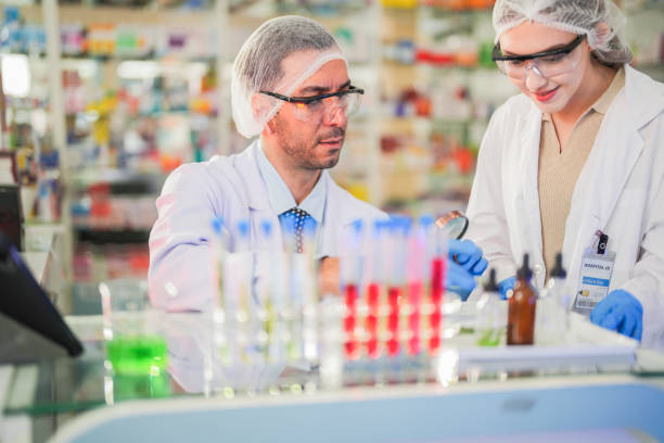 istock scientists perform experiments and record data. people arranges equipment with test tubes and chemicals for producing medicine and biochemistry. man hold tubes of chemical liquids and plant samples. 2160389325