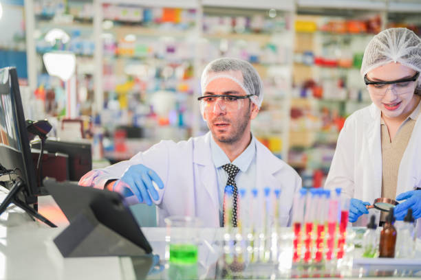 istock scientists perform experiments and record data. people arranges equipment with test tubes and chemicals for producing medicine and biochemistry. man hold tubes of chemical liquids and plant samples. 2160389374