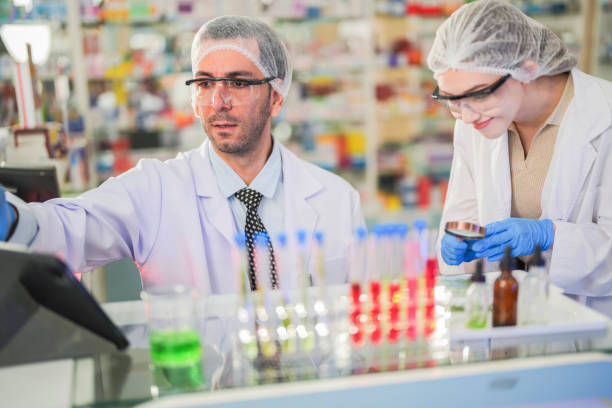 istock scientists perform experiments and record data. people arranges equipment with test tubes and chemicals for producing medicine and biochemistry. man hold tubes of chemical liquids and plant samples. 2160389416