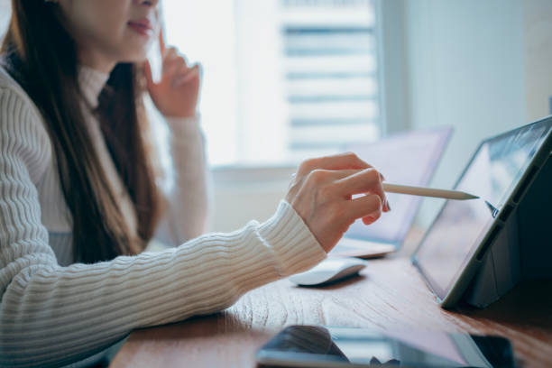 istock An Asian woman is using a laptop for remote video conferencing, presenting the concept of working from home or in an informal office setting. 2160393739