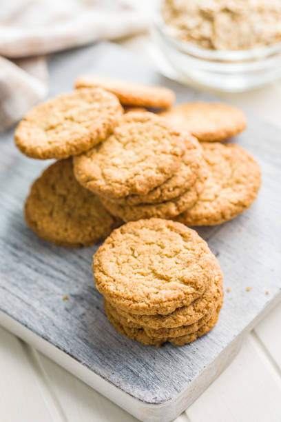 istock Tasty oatmeal cookies on cutting board on white table. 2160394929