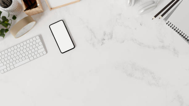 istock A white marble tabletop workspace features a keyboard, stationery, a smartphone, and a copy space. 2160397829