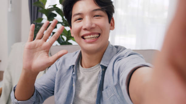 istock Cheerful Young Asian Man Waving During Video Call. 2160397974