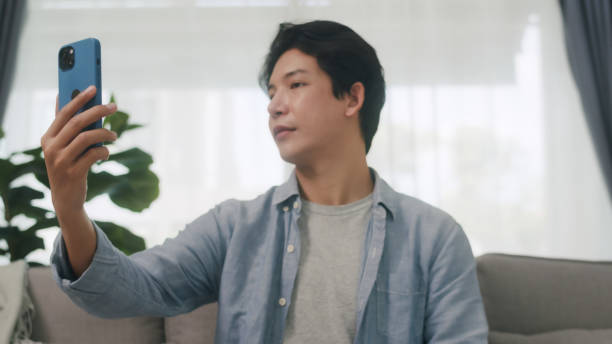 istock Young Asian Man Using Facial Recognition on Smartphone. 2160397982