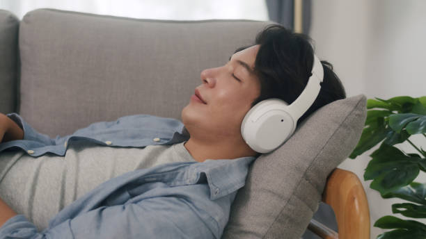 istock Man Relaxes with Music on Comfortable Sofa. 2160397994