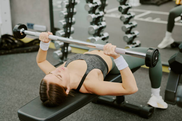 istock Young Woman Lying on Bench and Holding Barbell 2160398623