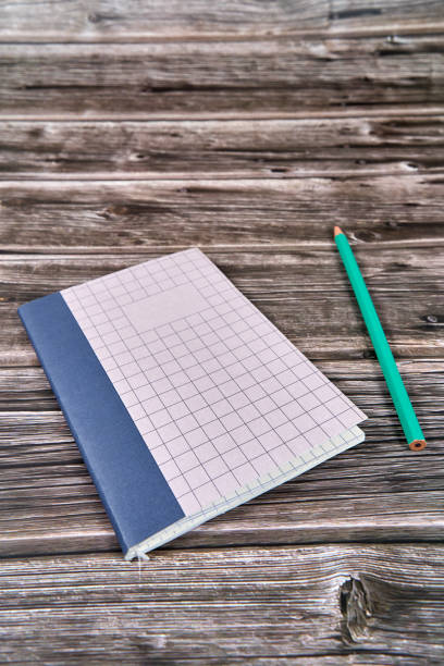 istock Notepad with crossed and parallel lines along with a pencil on a wooden desk. 2160399275