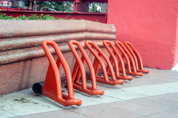 Metal bicycle rack stands empty in a grassy field, awaiting cyclists