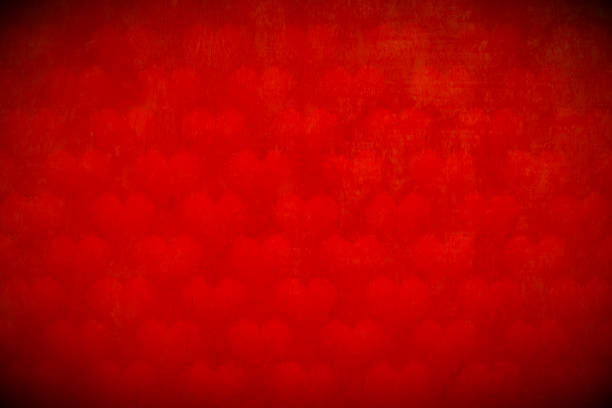 istock Love theme Valentine's Day Red maroon horizontal background - Small shaded hearts lined up in a row on wallpaper, Several many shaded smudged hearts all over vibrant maroon coloured backdrop with glow and vignette 2160402118