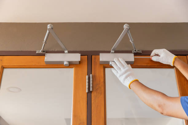 Handyman fixing door closer and adjust  hydraulic arm extended.