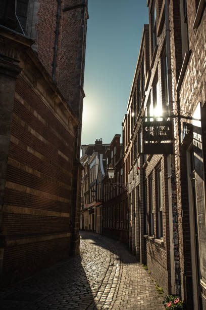 istock Sunlit Cobblestone Alleyway in De Wallen - Amsterdam, Netherlands 2160403451