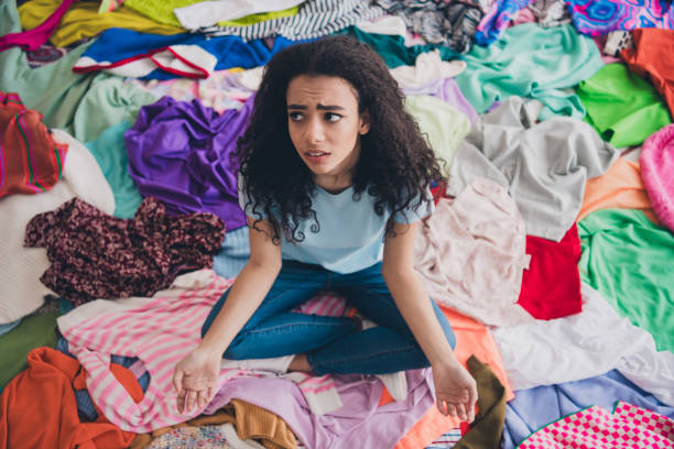istock High angle view full size photo of young girl sitting think pile stack clutter clothes apartment indoors 2160404433